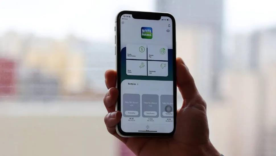 Pessoa segurando celular com aplicativo Nota Paraná