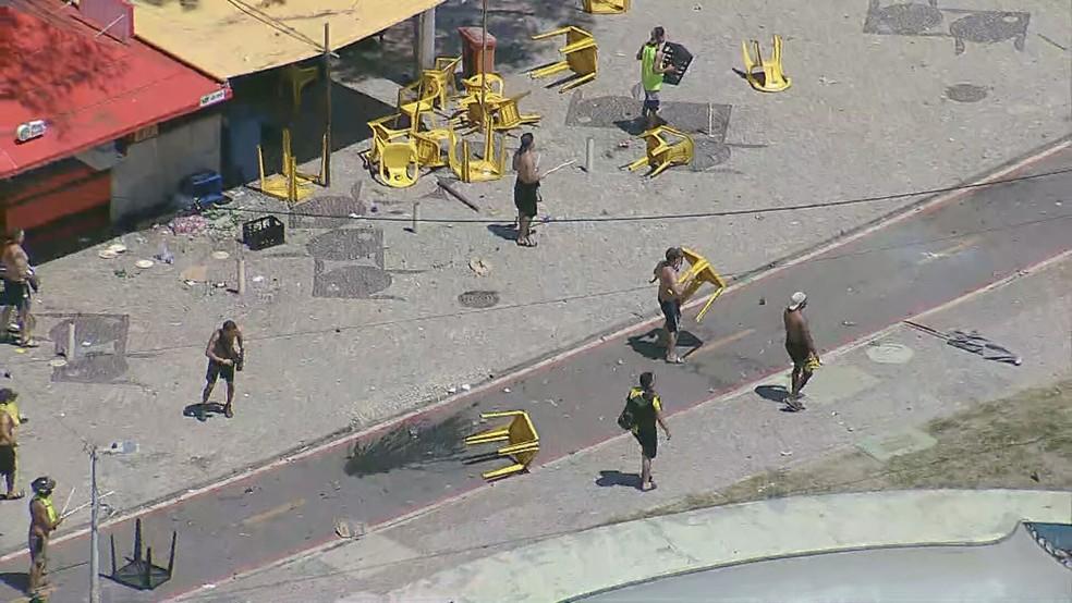 Torcedores do Peñarol usam mesas como escudo em confronto na orla do Recreio dos Bandeirantes