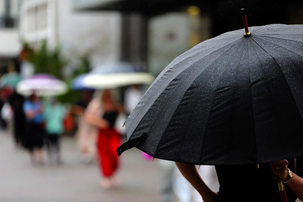 Morador com guarda-chuva no Centro de Florianópolis