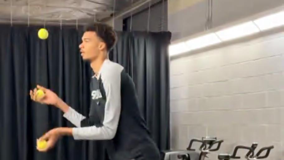 Victor Wembanyama malabarizando tênis antes do jogo