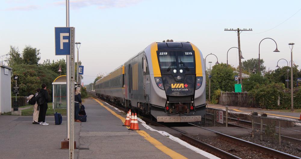 Trem de passageiros cinza, amarelo e preto na estação