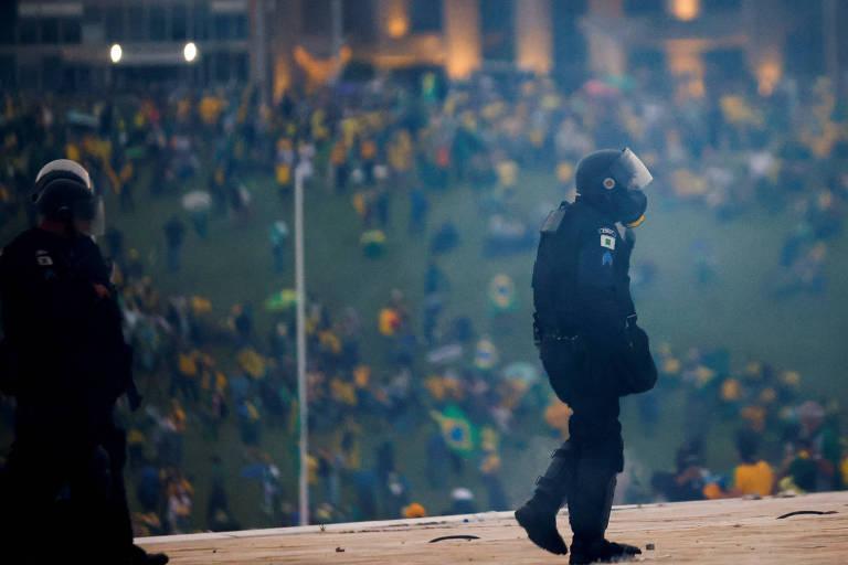 Policial em protesto com multidão ao fundo