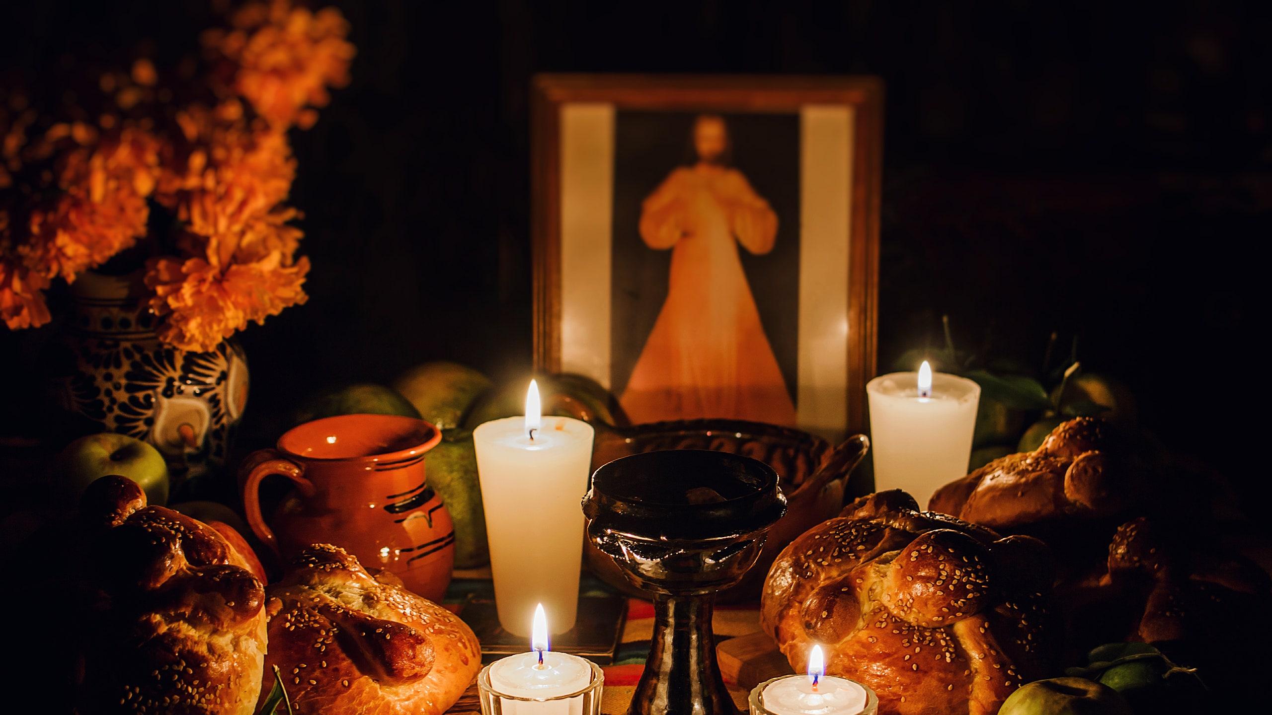 O que incluir em uma ofrenda do Dia de los Muertos, mostrando fotos, velas, jarros de água, pão e flores