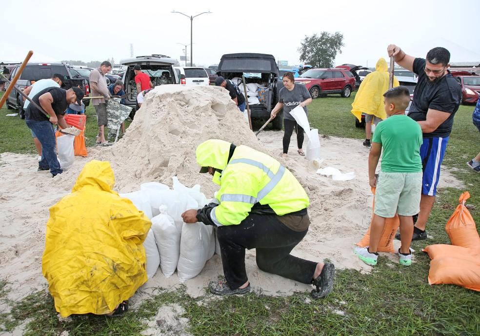 Moradores de Kissimmee, na Flórida, enchem sacos de areia para proteção contra a tempestade Milton, que virou furacão