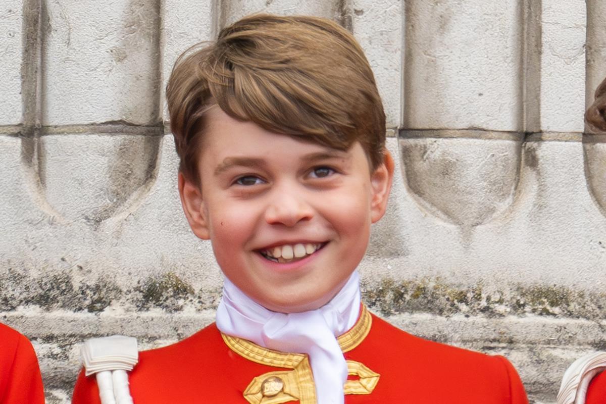 Príncipe George com traje formal vermelho, sorrindo