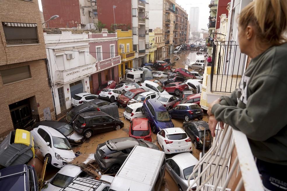 Carros empilhados em rua de Valencia após inundação