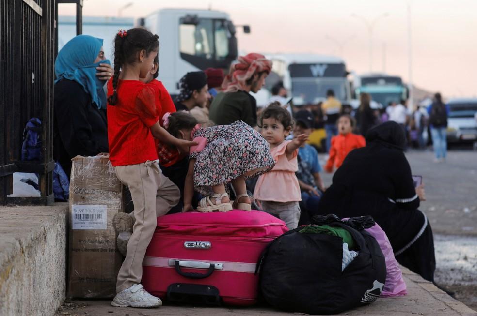 Crianças esperando na fronteira do Líbano com a Síria