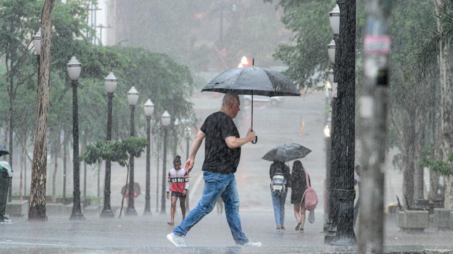 Pedestres enfrentam chuva forte na região central da cidade de São Paulo.