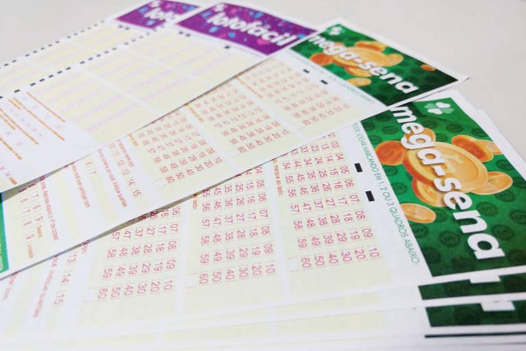 Vários bilhetes de loteria empilhados, incluindo bilhetes da Mega-Sena.