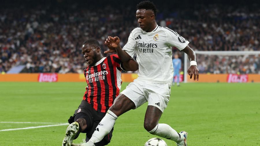 Vini Jr é marcado por Musah durante jogo entre Real Madrid e Milan pela Champions League.