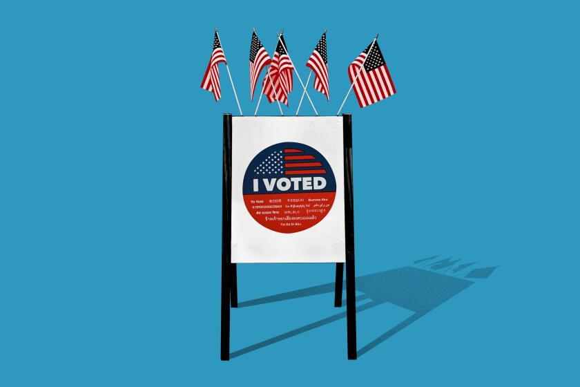 I Voted sticker on a sandwich board sign with flags.