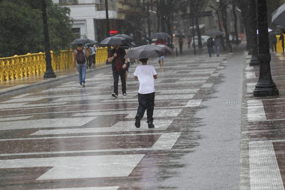 Pedestres enfrentam mais um dia de chuva na região do Viaduto Santa Ifigênia, no Centro