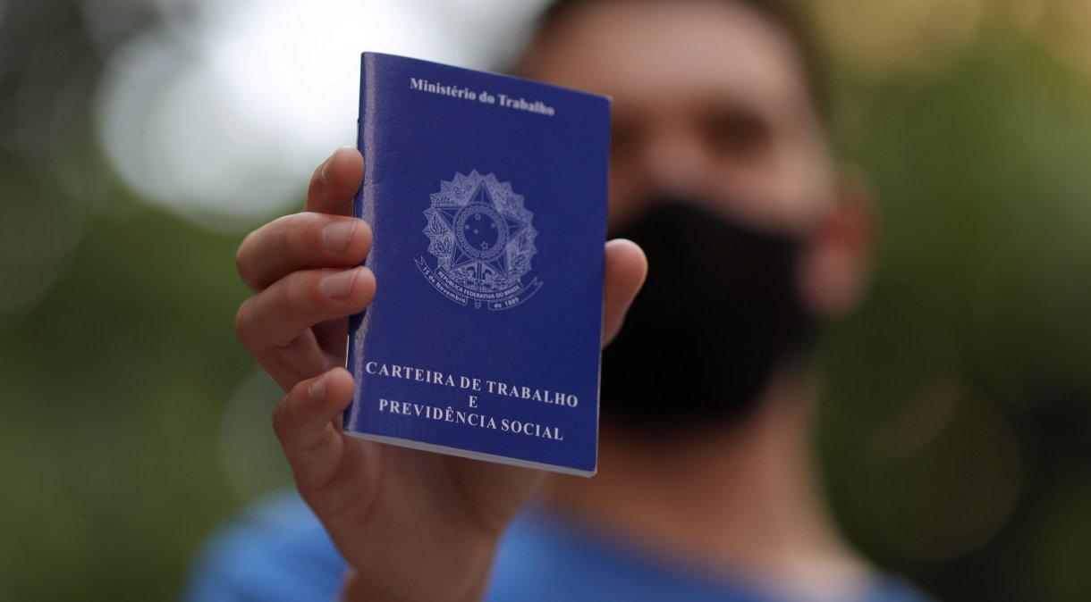 Homem segura carteira de trabalho em São Paulo.