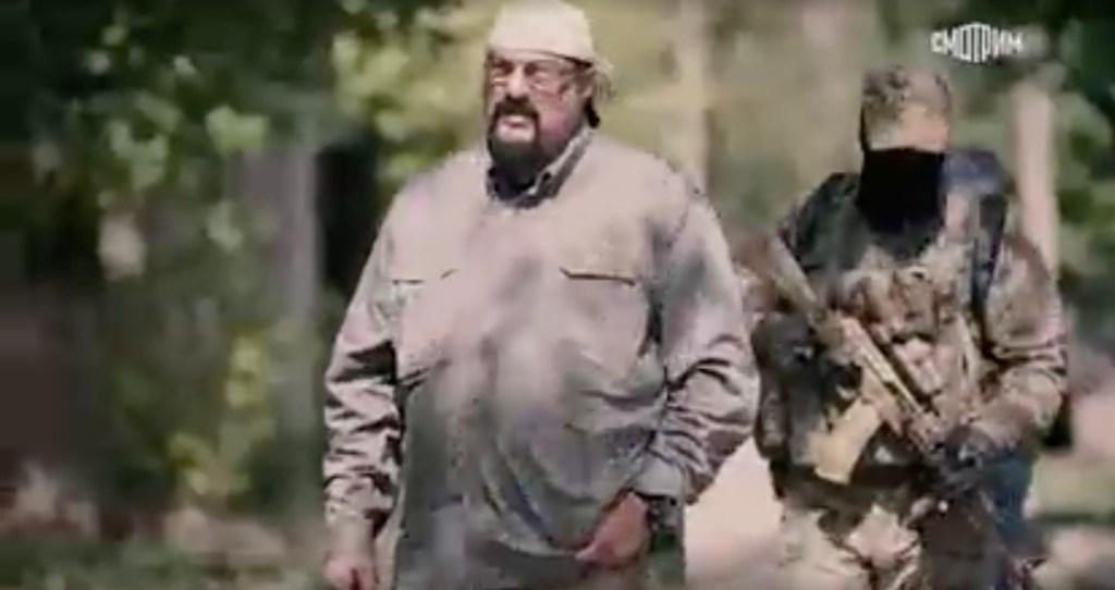 Seagal em visita ao território da Ucrânia, com roupas que pareciam estar estourando.