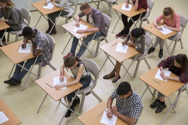 Alunos realizando vestibular em uma sala de aula