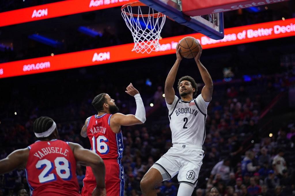 Cameron Johnson dos Nets arremessando contra Caleb Martin e Guerschon Yabusele dos Sixers