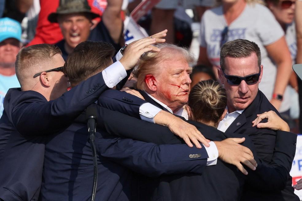 Com sangue no rosto, Trump é retirado do palco de comício em Butler, na Pensilvânia