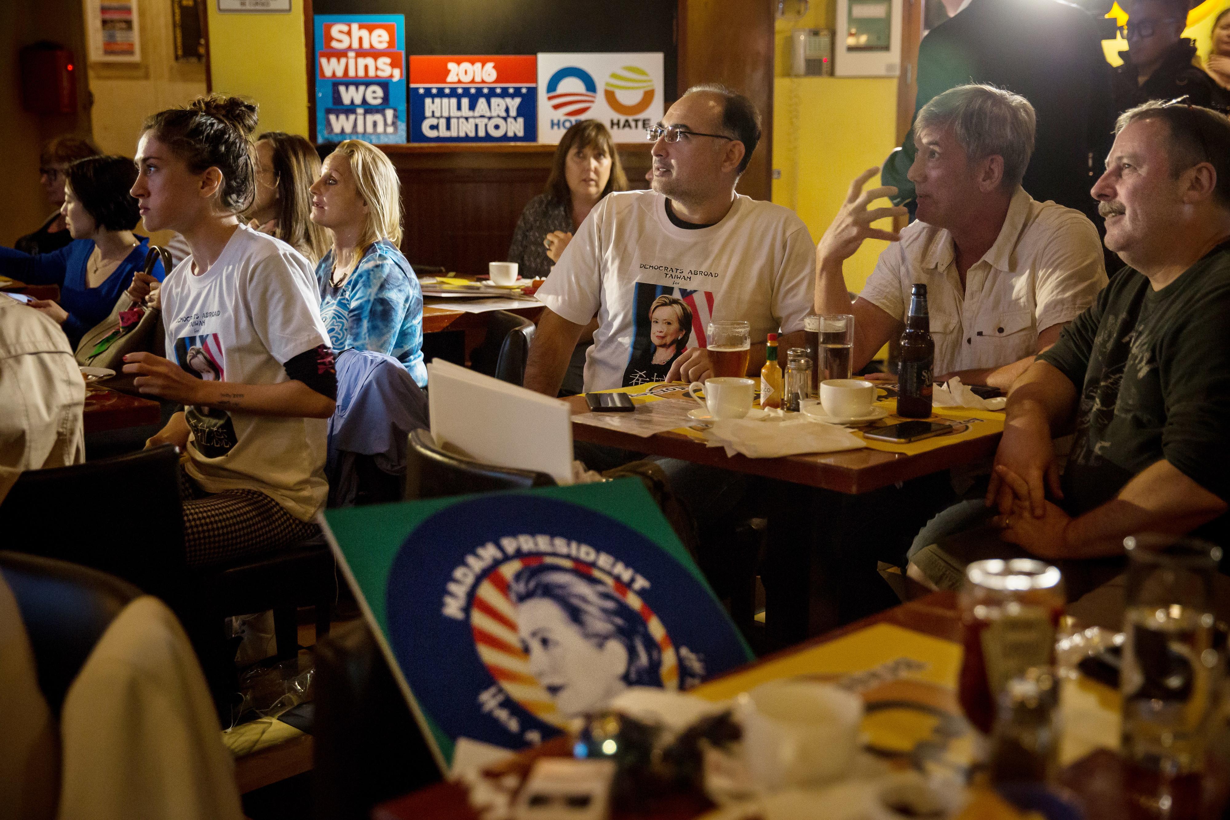 Pessoas em um watch party assistindo as eleições