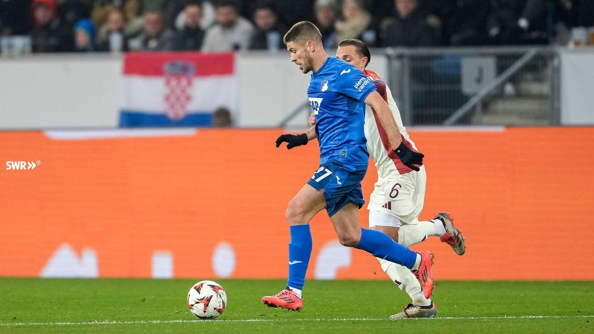 Andrej Kramaric (TSG Hoffenheim) e Maxence Caqueret (Olympique Lyon) disputando a bola.