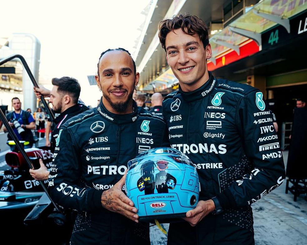 George Russell e Lewis Hamilton exibem capacete que jovem britânico usará na despedida do colega, no GP de Abu Dhabi da F1 2024