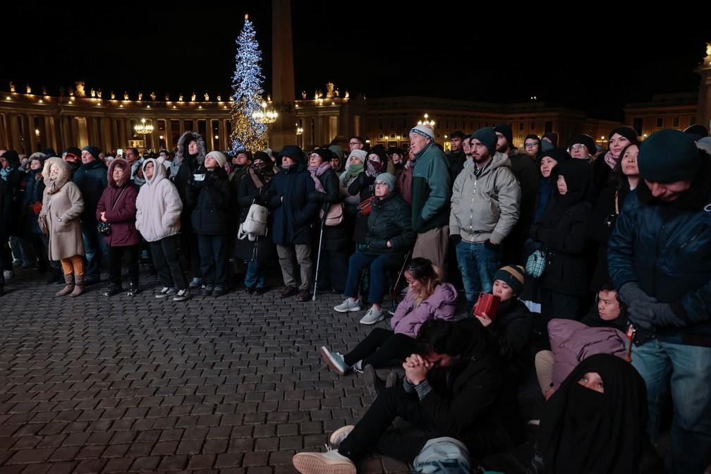 Fiéis orando e assistindo à Missa do Galo na Praça de São Pedro, no Vaticano
