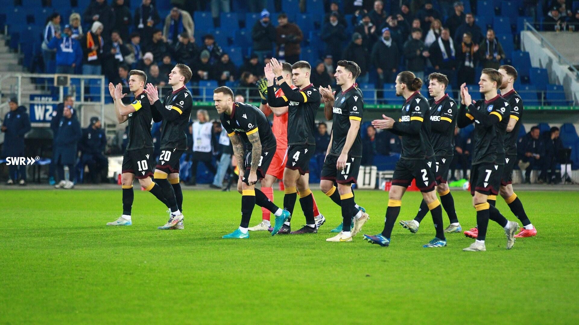 Jogadores do Karlsruher SC aplaudem os torcedores após partida em casa.