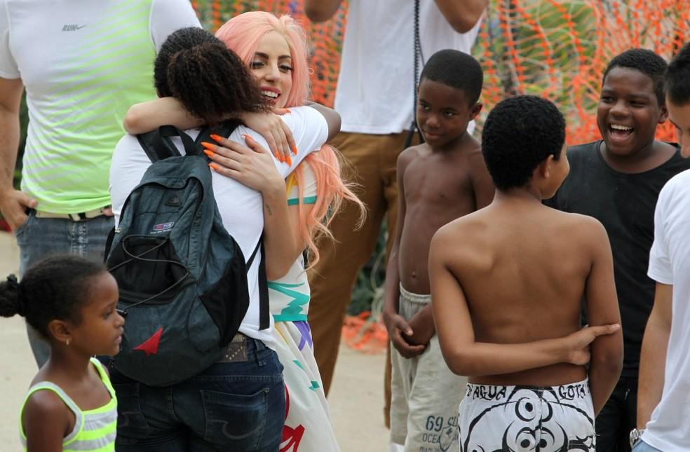 Lady Gaga abraça fã no Morro do Cantagalo, quando se apresentou no Rio