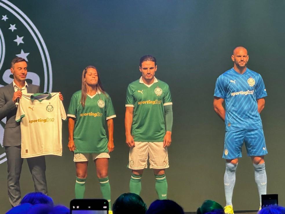 Laís Estevam, Veiga e Weverton apresentam camisas do Palmeiras com novo patrocinador.