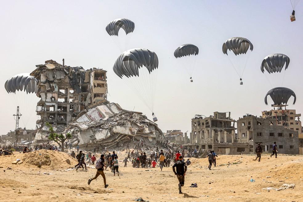 Pessoas em Gaza pegando ajuda humanitária.