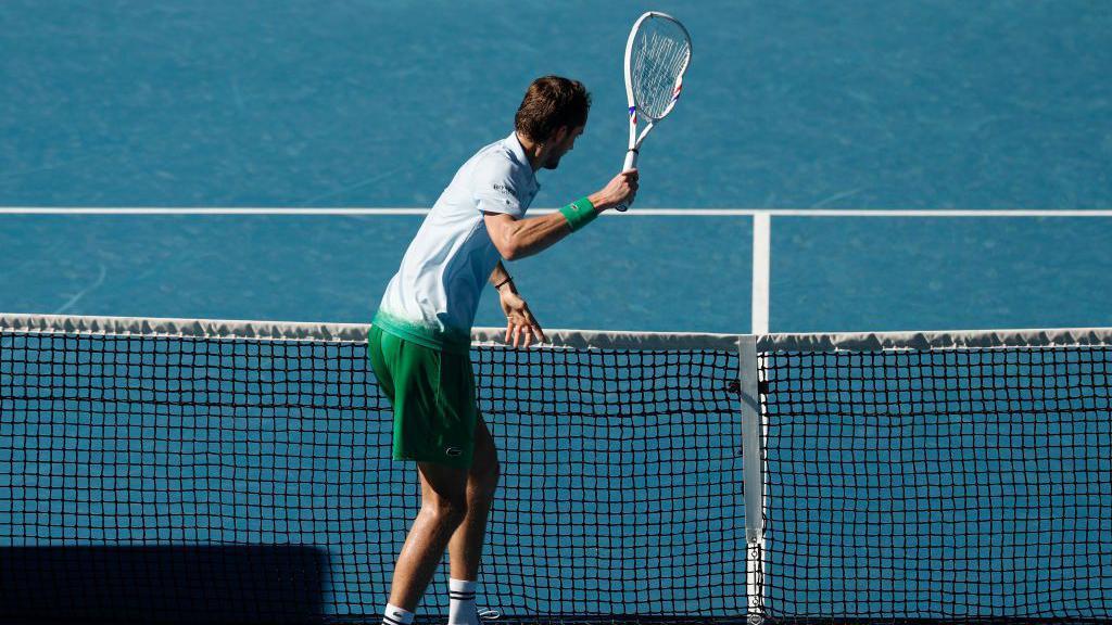 Daniil Medvedev smashes a camera on the net during his match.