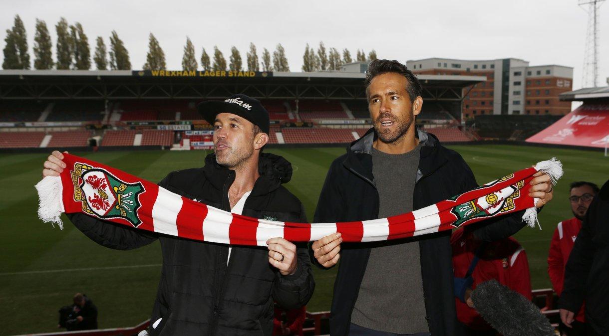 Atores Ryan Reynolds e Rob McElhenney em partida do Wrexham, do qual são proprietários.