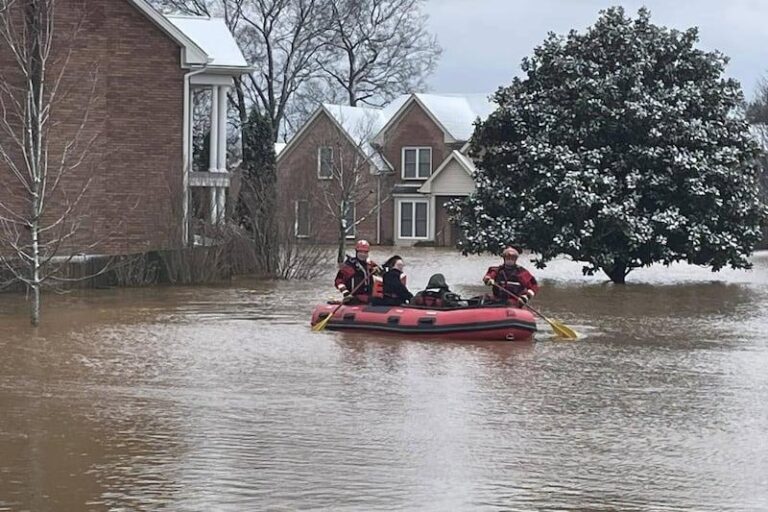 A mulher é resgatada de veículo em área inundada e enfrenta acusação por DUI