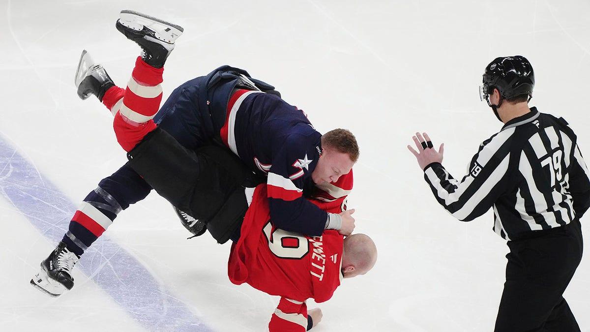 Jogadores dos EUA e Canadá lutando durante o jogo.