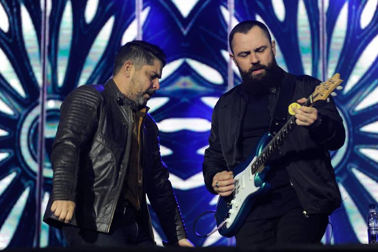Dupla de sertanejos cantando e tocando guitarra no palco