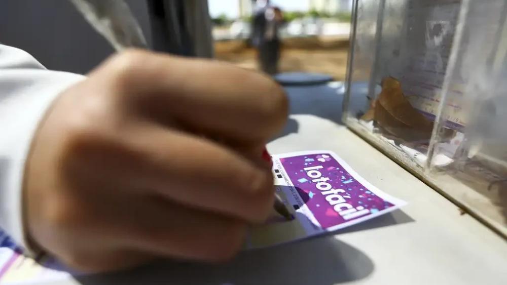Mão marca números em volante da Lotofácil