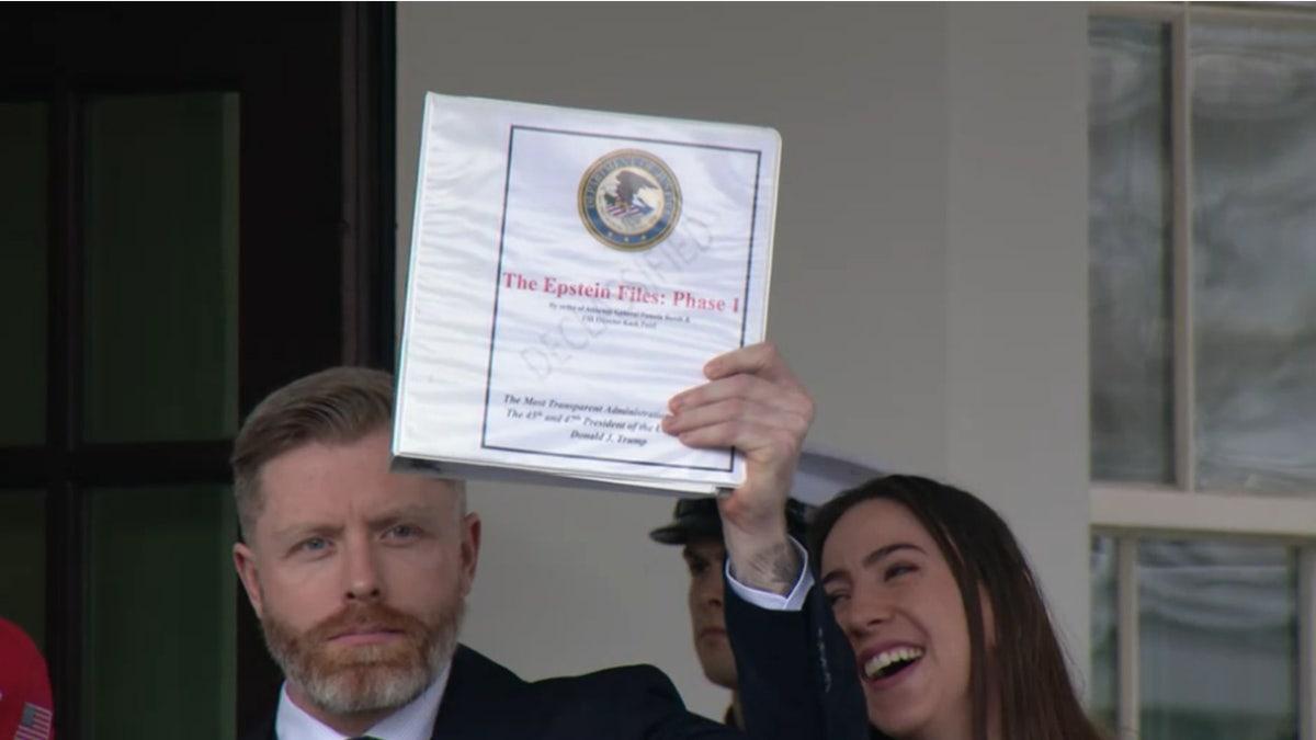 Rogan O'Handley segurando um binder com o título 'EPSTEIN FILES: PHASE 1'