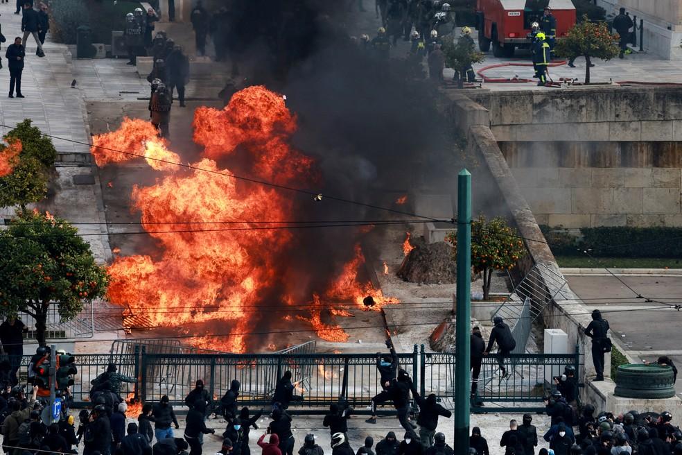 Manifestantes atiram objetos explosivos contra polícia em frente ao Parlamento grego em Atenas em 28 de fevereiro de 2025.