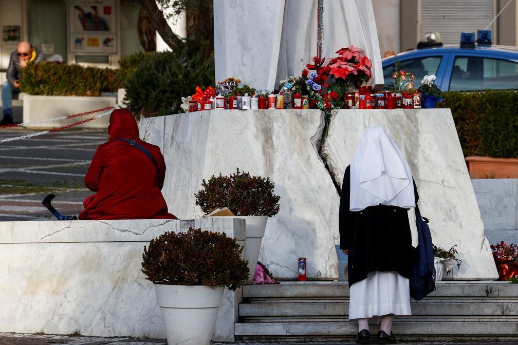 Mulher e Freira oram pela saúde do papa Francisco na porta de hospital em Roma