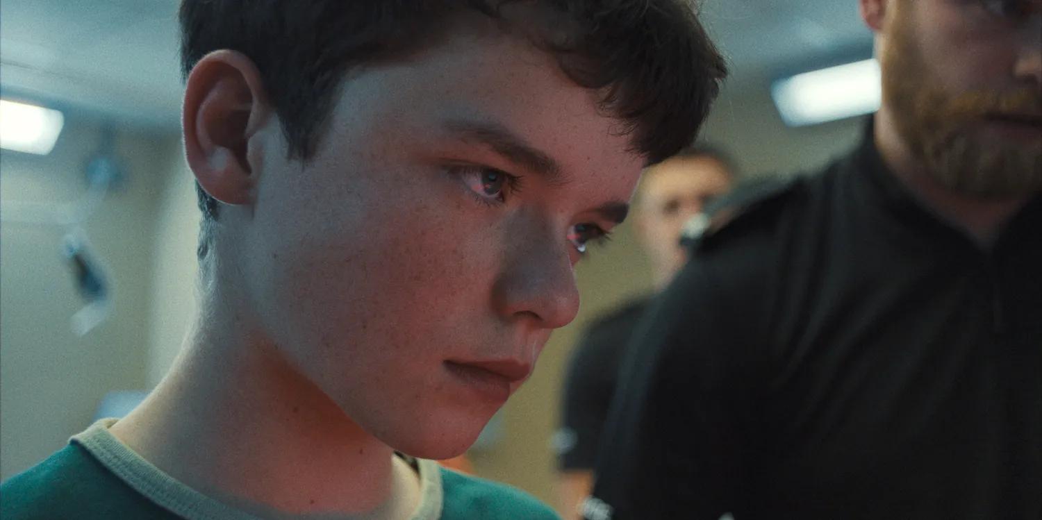 Close-up de um jovem adolescente, com expressão tensa.