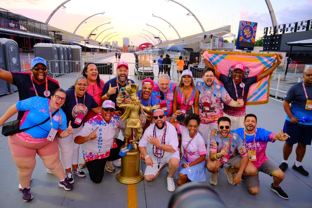 Integrantes da Rosas de Ouro exibem o troféu de campeões do carnaval de 2025