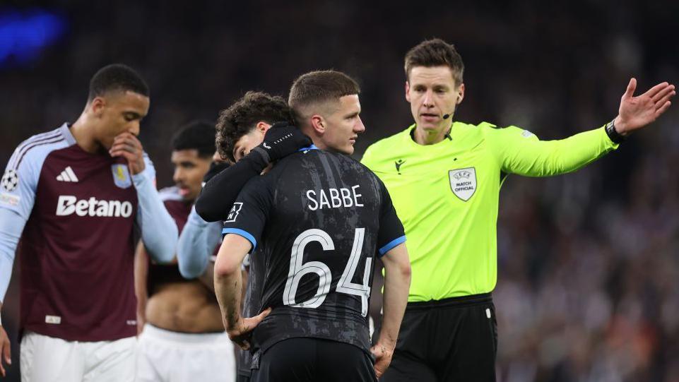 Dejected Kyrian Sabbe é consoled by Club Brugge team-mates after being sent off at Aston Villa in the Champions League.