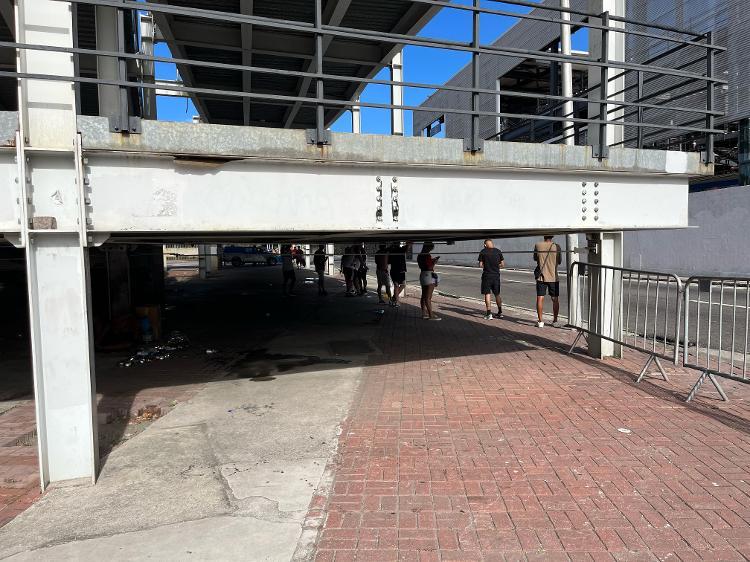 Torcedores do Flamengo se protegem do calor sob rampa de acesso à estação de trem