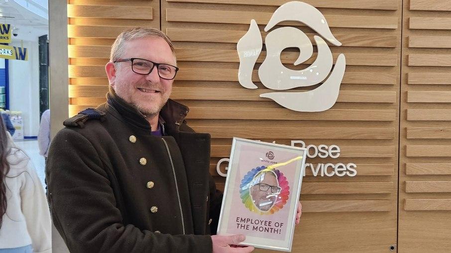 Steve Lovell com a placa de funcionário do mês.