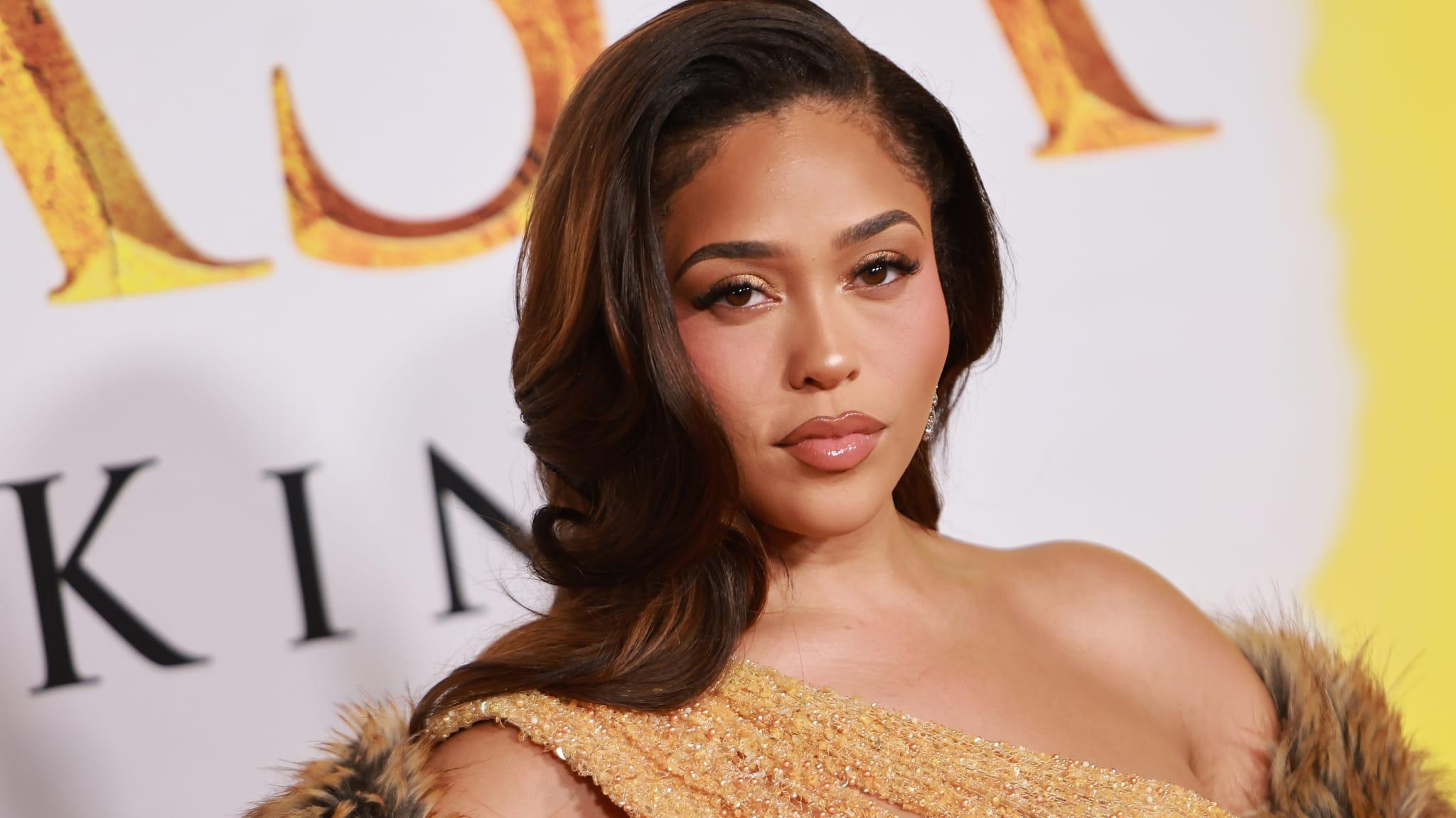Jordyn Woods em evento com vestido dourado