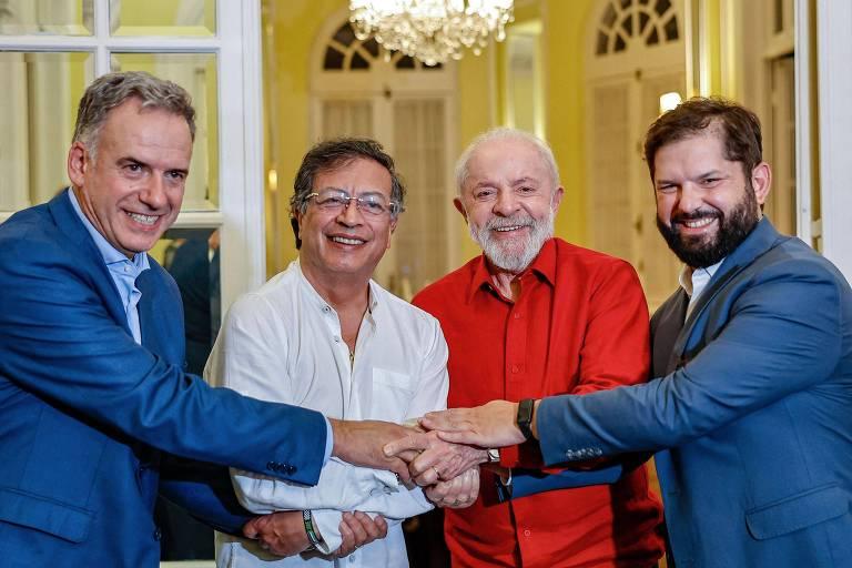 Líderes políticos sorrindo e segurando as mãos em um gesto de união