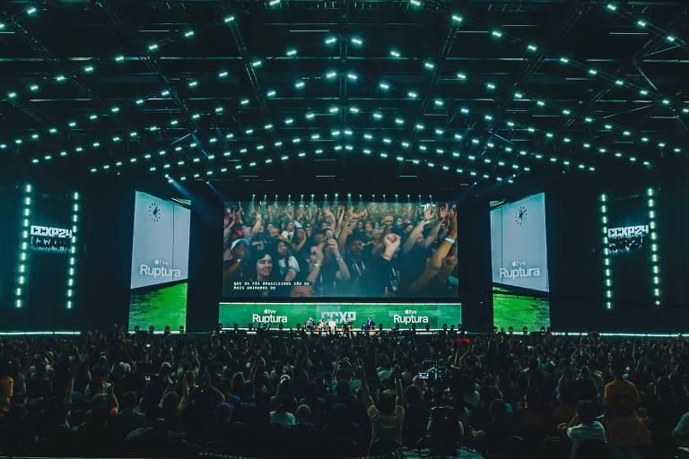 Auditório da CCXP iluminado com pessoas animadas