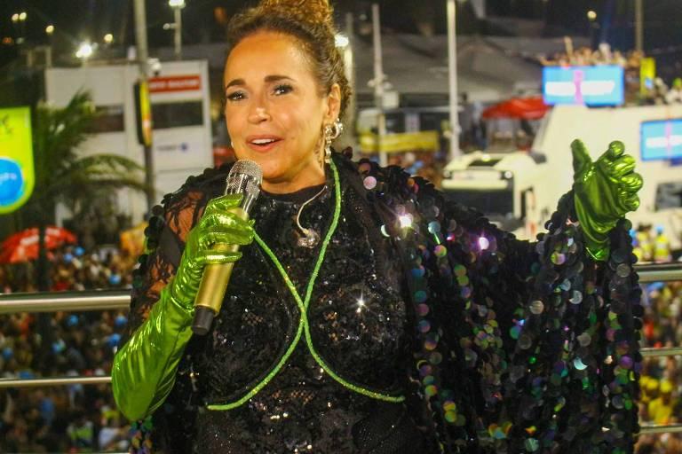 Artista se apresentando em um palco durante o Carnaval, rodeada por uma multidão.