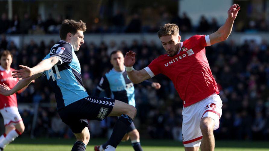 Adam Reach de Wycombe Wanderers sendo desafiado por Sam Smith do Wrexham