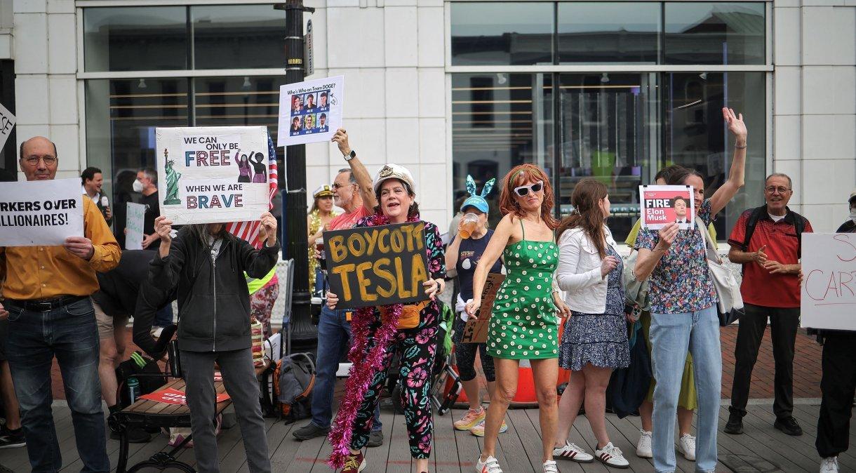 Manifestantes protestam contra Elon Musk em frente a uma concessionária Tesla no bairro de Georgetown, em Washington, DC.
