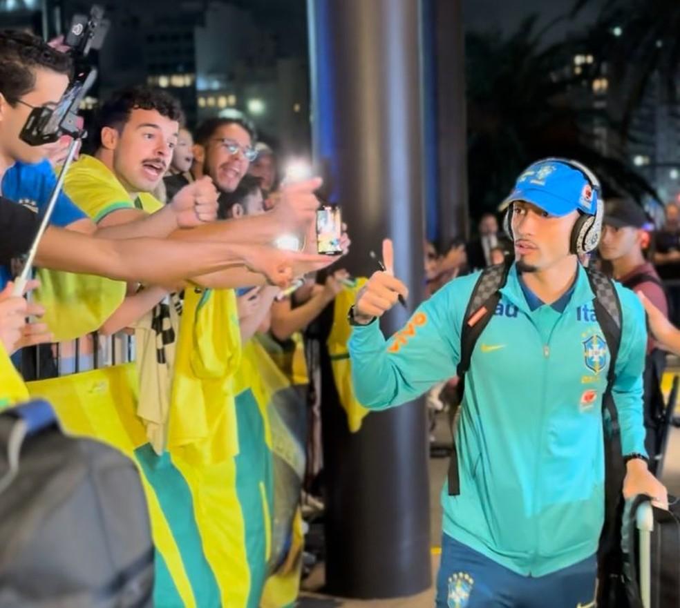 Raphinha tira foto com torcedores brasileiros na chegada da Seleção a Buenos Aires